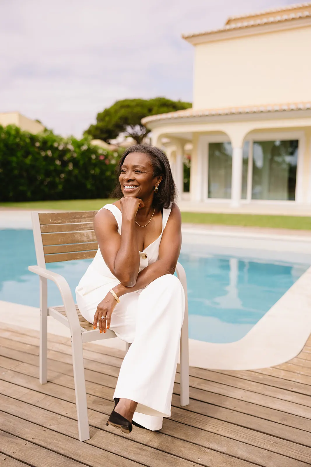 jennifer seated on a chair by a pool